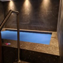 a black custom tiled spa with sauna