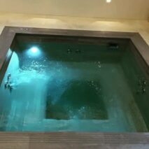 a grey tile and mosaic custom spa